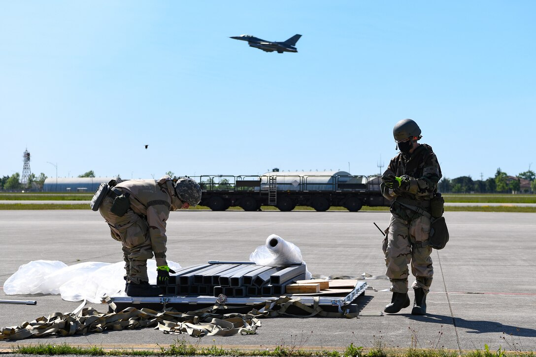 U.S. Airmen from the 724th Air Mobility Squadron unload cargo during a Nodal Lightning exercise at Aviano Air Base, Italy, May 18, 2021. The exercise started with a simulated air attack followed by other attacks and injuries to teammates. (U.S. Air Force photo by Airman 1st Class Thomas S. Keisler IV)