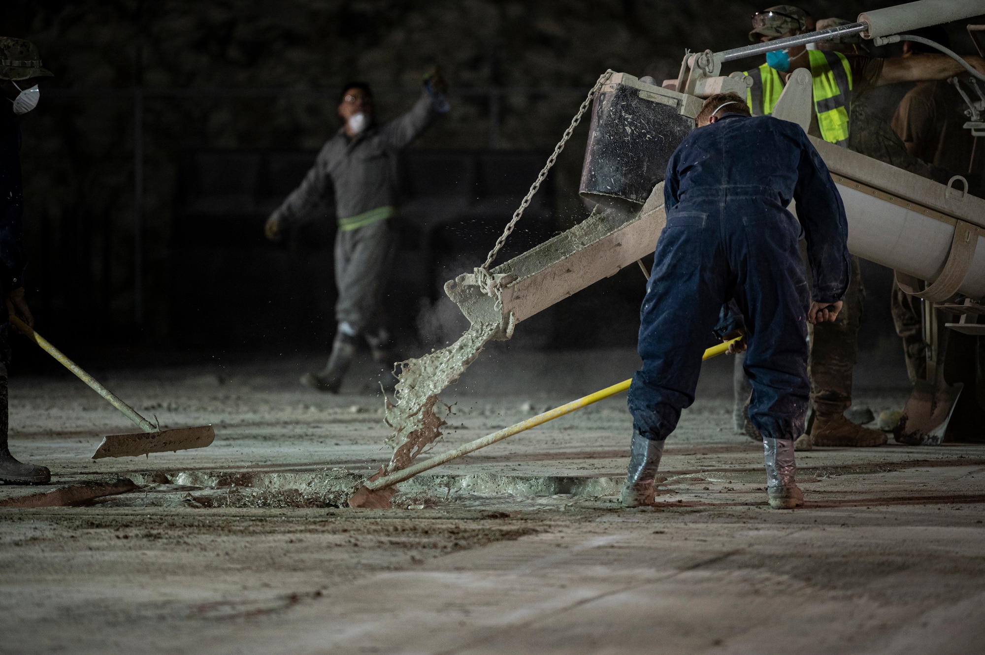Cement is being poured into a hole in the ground.