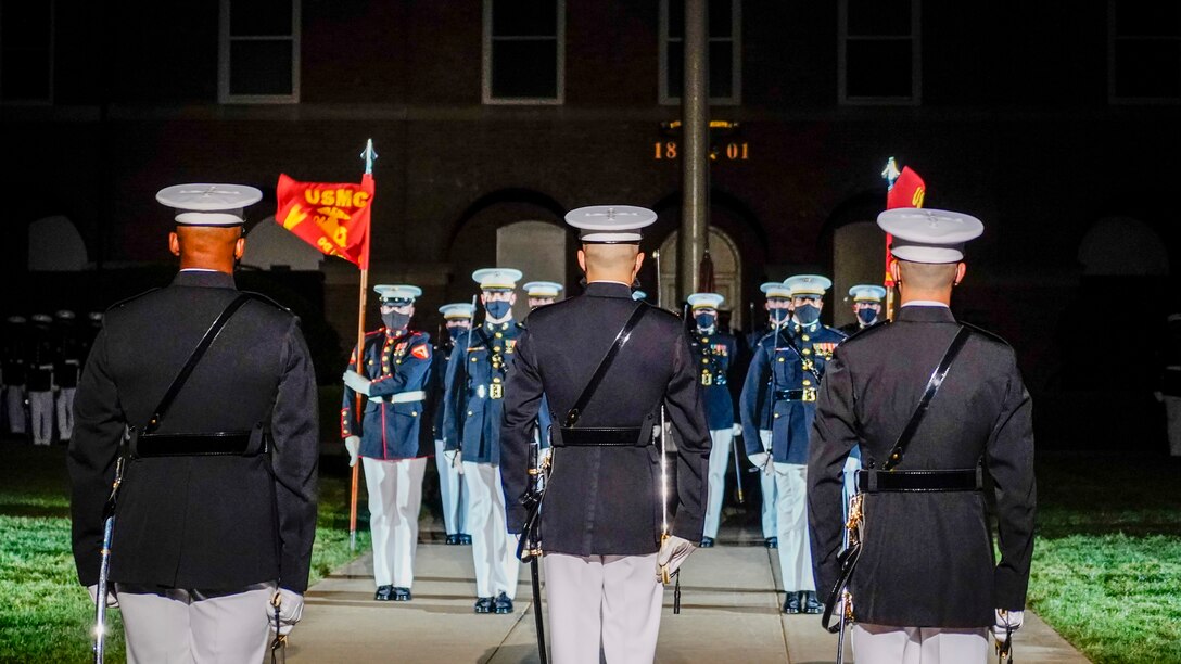 Marines with the parade staff stand at the position of attention during the Friday Evening Parade at Marine Barracks Washington, May 21, 2021. The guest of honor for the evening was Her Excellency Karen E. Pierce, DCMG British Ambassador to the United States, and the hosting official for the evening was Lt. Gen. Lewis A. Craparotta, commanding general, Training and Education Command. (U.S. Marine Corps photo by Sgt. Jason Kolela)