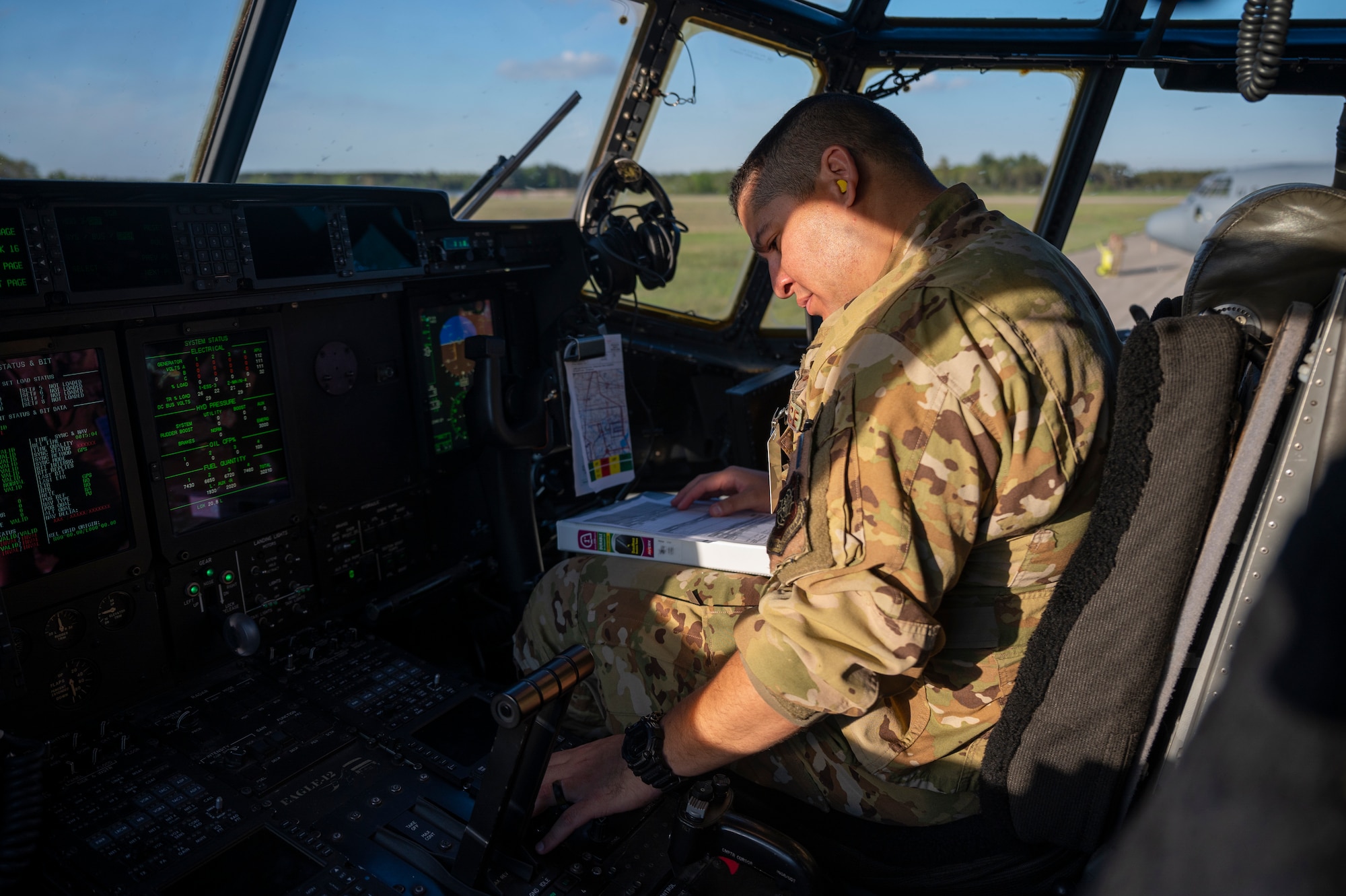 An Airman preforms a pre-flight check of a C-130J