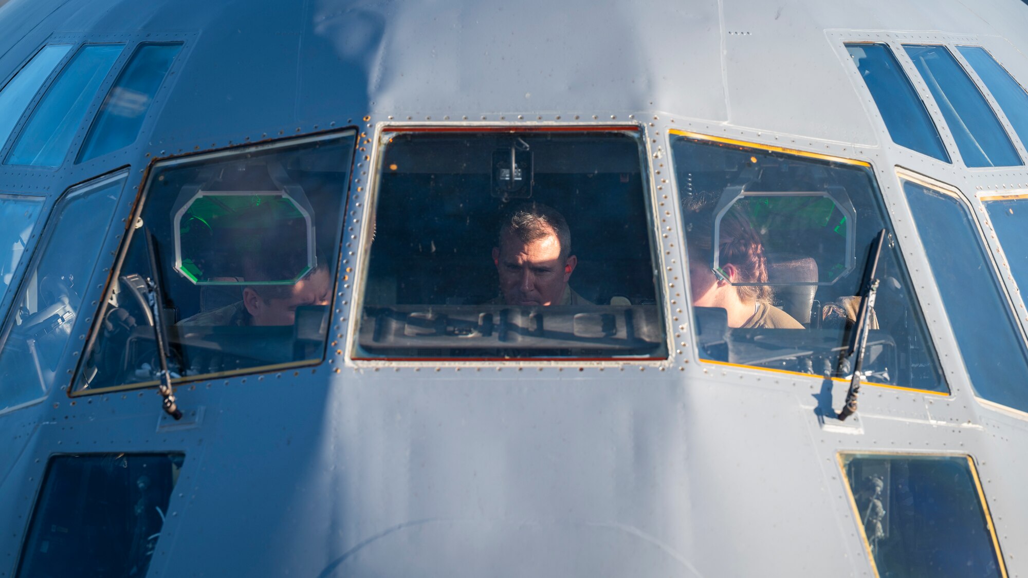 Airmen prepare pre-flight checks of a C-130J