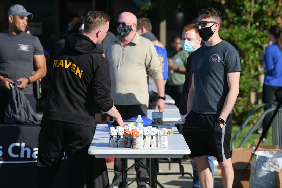 An Airman picks up a refreshment, provided by members of Chapel 1, after running the 5K event during Wingman/Shipmate Day at Joint Base Andrews, Md., May 11, 2021. Wingman/Shipmate Day is meant for Airmen to compete and strengthen the bonds between squadrons at JBA with activities such as basketball, golf, tennis, music and other family events. (U.S. Air Force photo by Airman 1st Class Bridgitte Taylor)