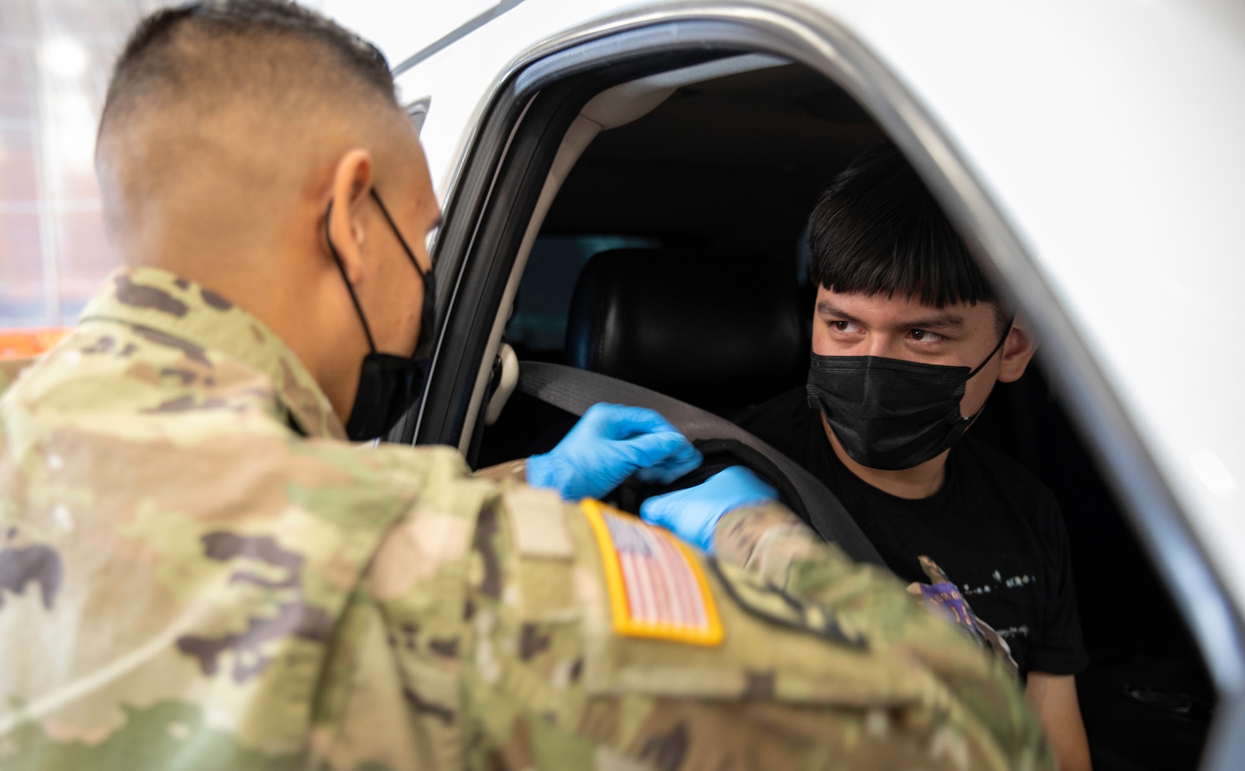 Service member administers COVID-19 vaccine to teen from car