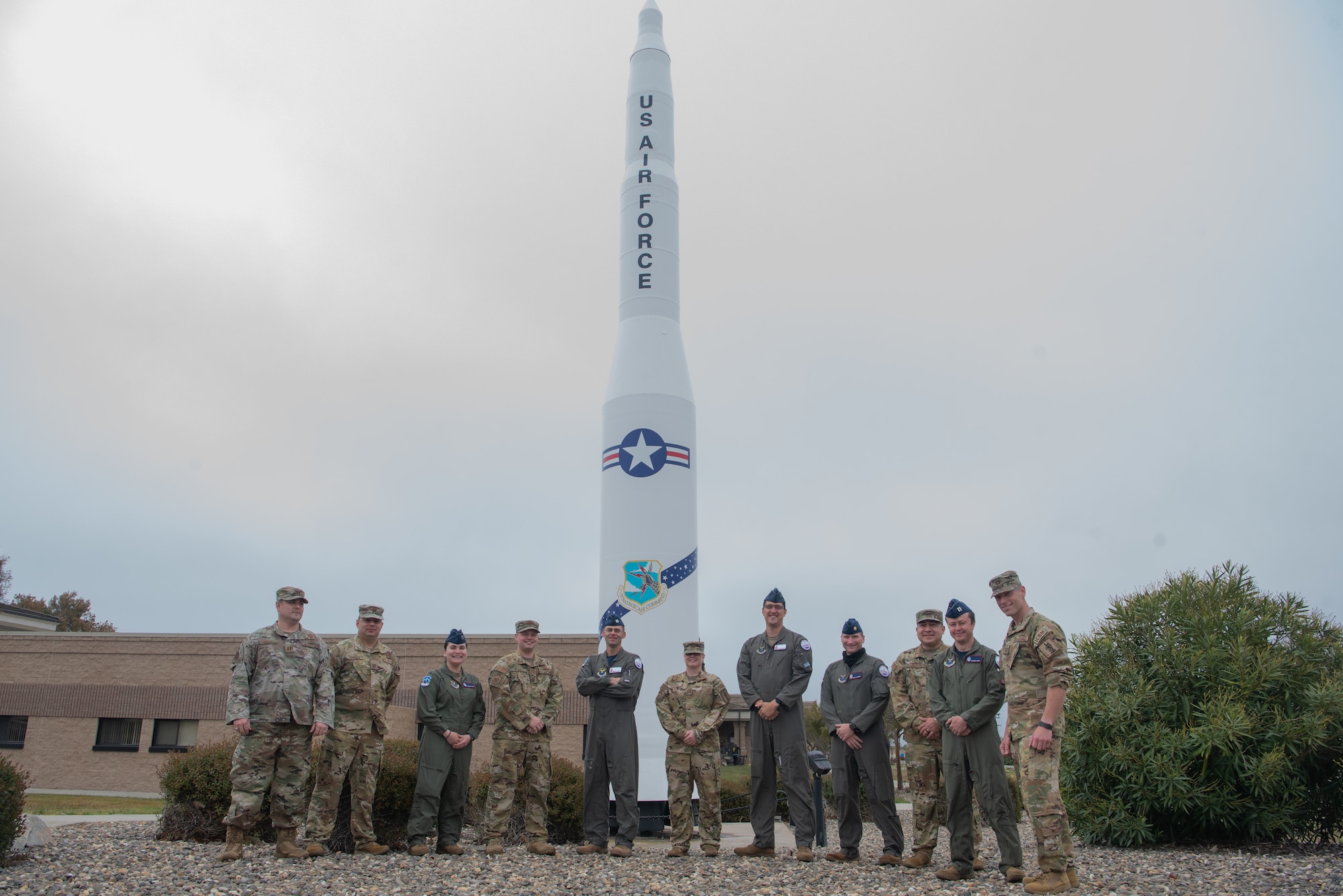 TOP HAND members pose for a photo in front of a Minuteman II missile display.