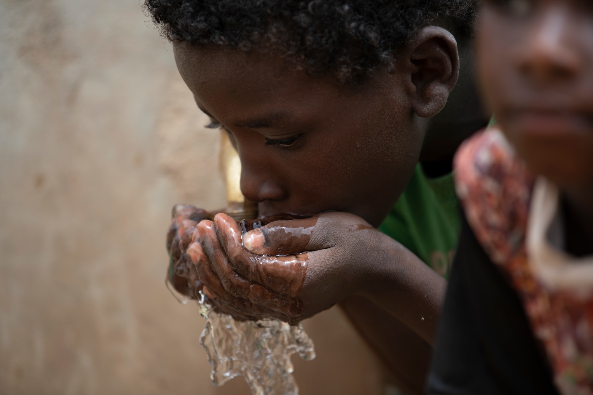 A Nigerien boy drinks water from a well outside of Agadez, Niger. The well was recently converted to a solar powered well with the help of Air Base 201. (U.S. Air Force photo by Tech. Sgt. Perry Aston)