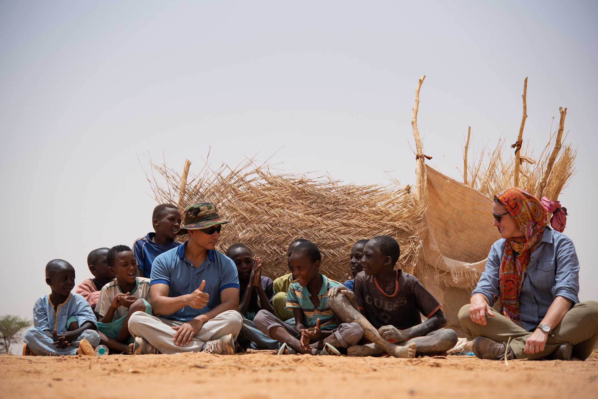 U.S. Air Force Maj. Hoang Nguyen, 435th Air Expeditionary Wing chaplain, and U.S. Army Staff Sgt. Cana Garrison, Civil Affairs Team 204, interact with Nigerien children at a village in Agadez, Niger, June 27, 2019. The civil affairs team helps connect the local community with the military community, which strengthens their partnership. (U.S. Air Force photo by Staff Sgt. Devin Boyer)