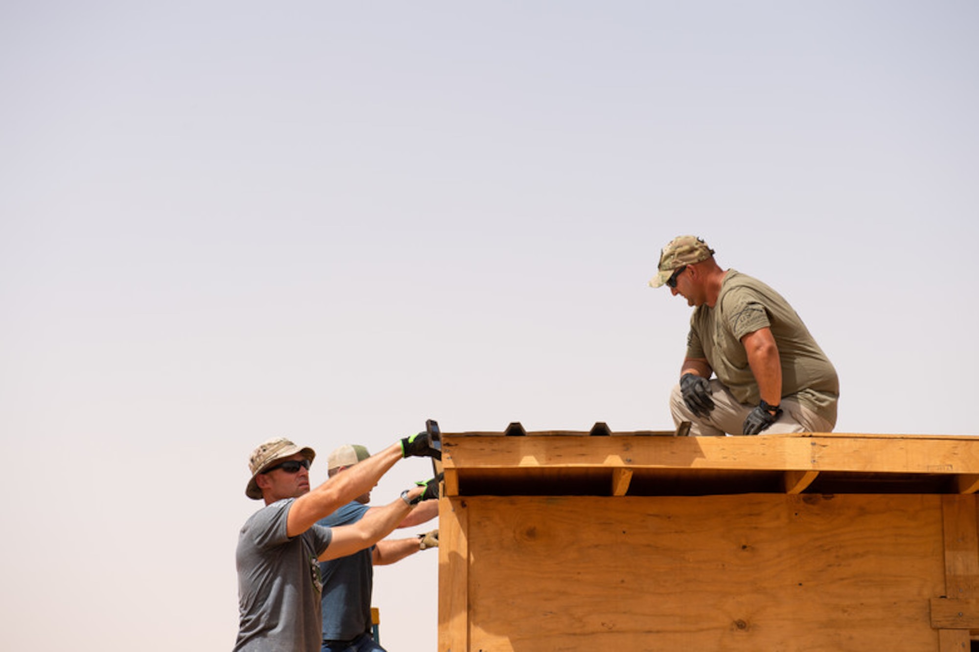 Airmen assigned to the 724th Expeditionary Air Base Squadron civil engineer flight install tin roofing on a classroom at a village in Agadez, Niger, June 27, 2019. The Airmen built the entire classroom using leftover wood from Air Base 201 and topped it off with locally purchased tin for the roof. (U.S. Air Force photo by Staff Sgt. Devin Boyer)