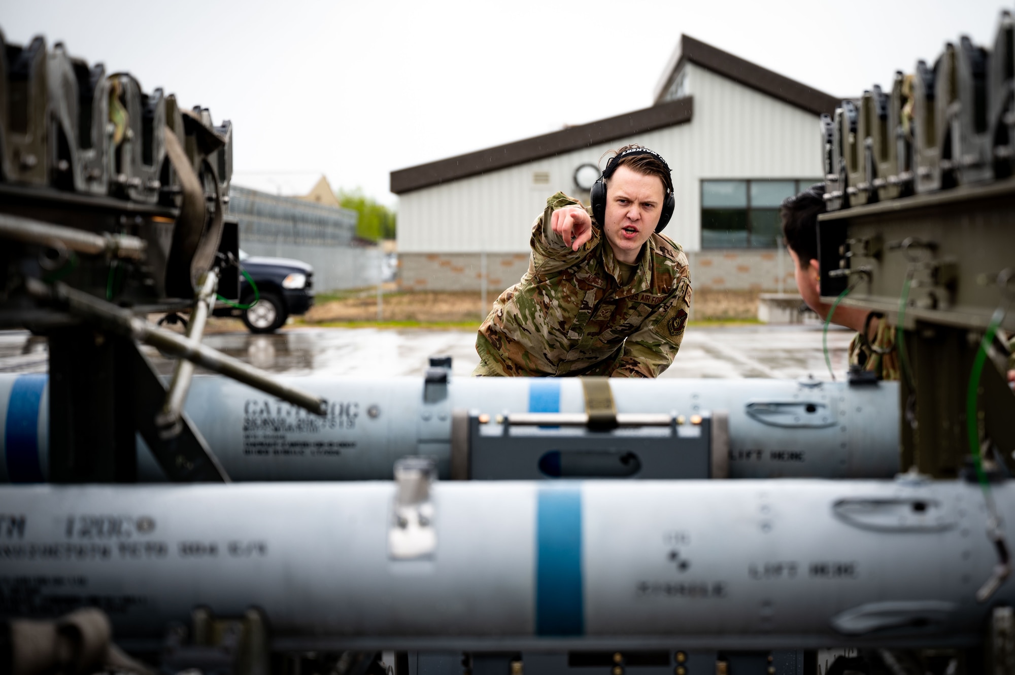 U.S. Air Force Senior Airman Trever Nichols, a 355th Aircraft Maintenance Unit weapons load crew member, points at the bomb rack during a load competition, May 21, 2021, on Eielson Air Force Base, Alaska.
