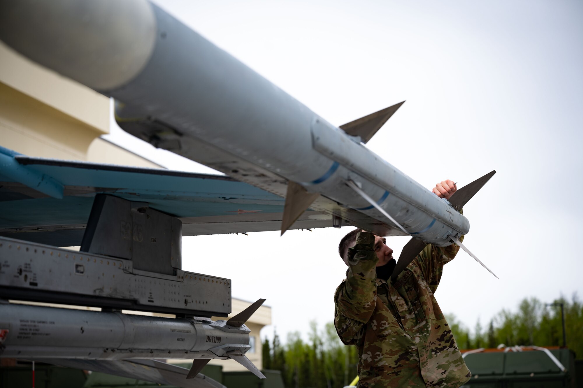 U.S. Air Force Senior Airman Dorian Hall, an 18th Aircraft Maintenance Unit weapons load team member, installs a buffer connector during a load competition, May 21, 2021, on Eielson Air Force Base, Alaska.