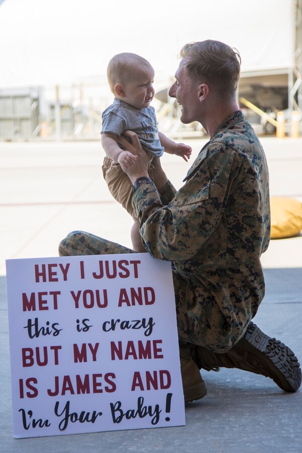 A U.S. Marine with Marine Fighter Attack Squadron 122 meets his son for the first time upon return from deployment with the 15th Marine Expeditionary Unit (MEU) to Marine Corps Air Station Yuma, Arizona, May 18, 2021.