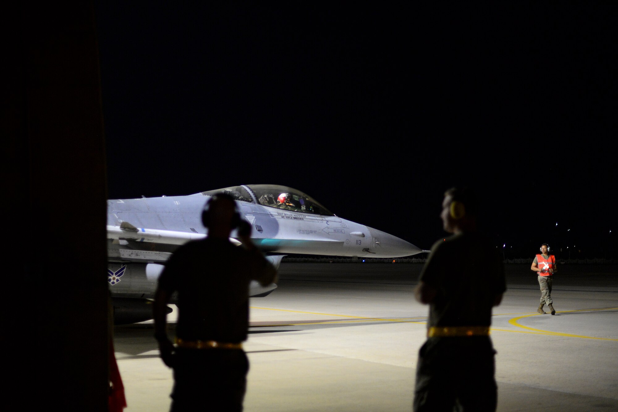 Flight chiefs supervise an Airman on the flight line.