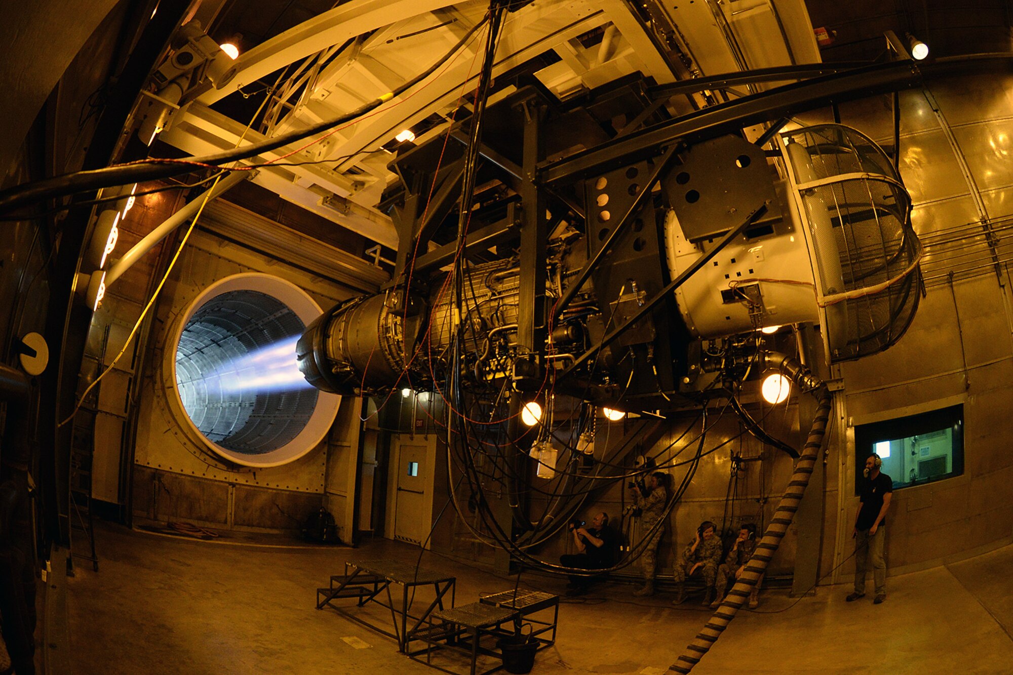 Airmen from 2d Audiovisual Squadron film an F-16 jet engine in max power during a test in the 576th Aircraft Maintenance Squadron’s hush house engine facility at Hill Air Force Base, Utah, June 5, 2019.  The shop is responsible for performing organizational level maintenance on more than 200 engines per year. The shop’s maintenance tasks include engine inspections, external engine component removal and replacement, repairs, and troubleshooting during flight line and test cell operations.  (U.S. Air Force photo by Alex R. Lloyd)