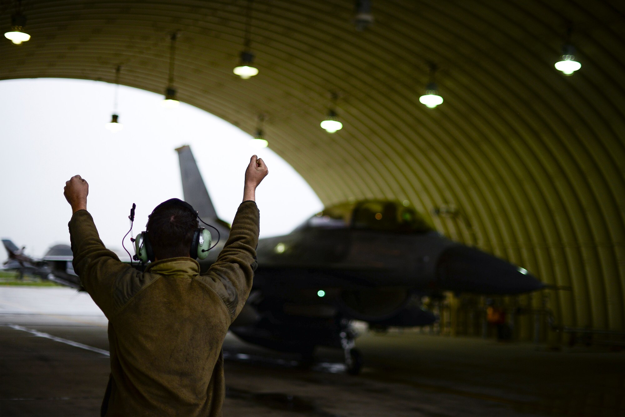 An Airman marshals a jet.