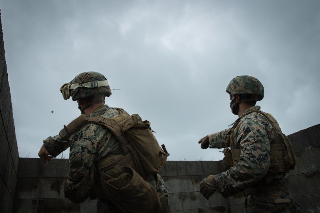U.S. Marine Corps Gunnery Sgt. Ryan Tomlin, right, the common skills training unit chief with Tactical Readiness Training Platoon, Combat Logistics Regiment 37, 3d Marine Logistics Group (MLG), guides Lance Cpl. Nicholas Irving, a landing support specialist with 3d Landing Support Battalion, 3d MLG, in deploying the M67 Fragmentation Grenade on Range 30, Okinawa, Japan, April 24, 2021. 3d MLG, based out of Okinawa, Japan, is a forward deployed combat unit that serves as III Marine Expeditionary Force’s comprehensive logistics and combat service support backbone for operations throughout the Indo-Pacific area of responsibility. (U.S. Marine Corps photo by Lance Cpl. Courtney A. Robertson)