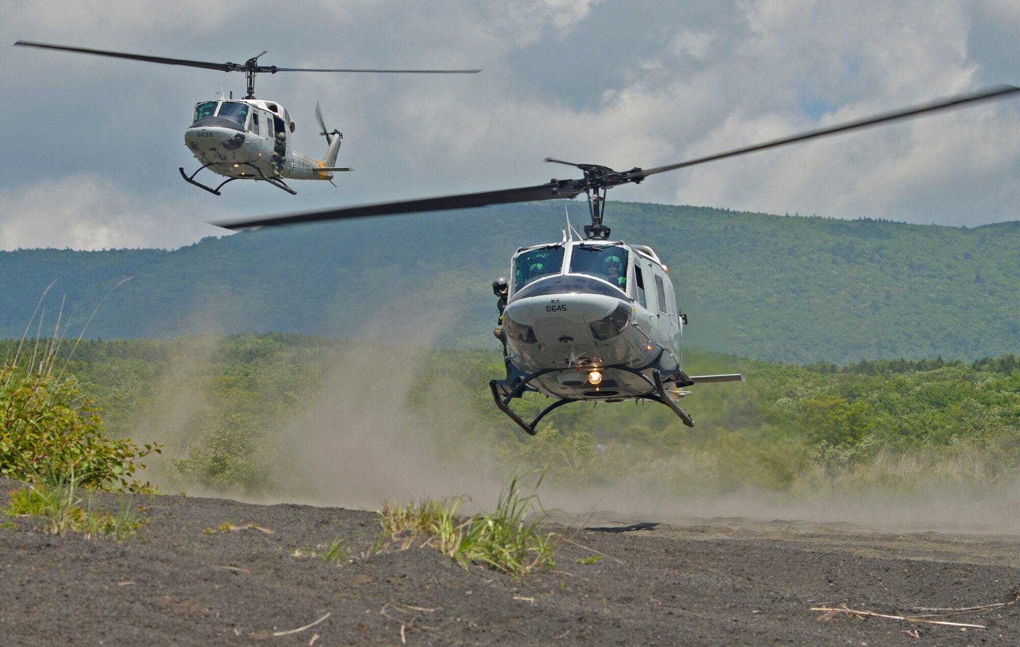 Two UH-1N Iroquois with the 459th Airlift Squadron take off from a drop zone near Mt. Fuji, Japan, June 3, 2016. The 459 AS regularly conducts training missions to remain proficient with flight skills necessary to support contingencies. (U.S. Air Force photo by Senior Airman David Owsianka/Released)