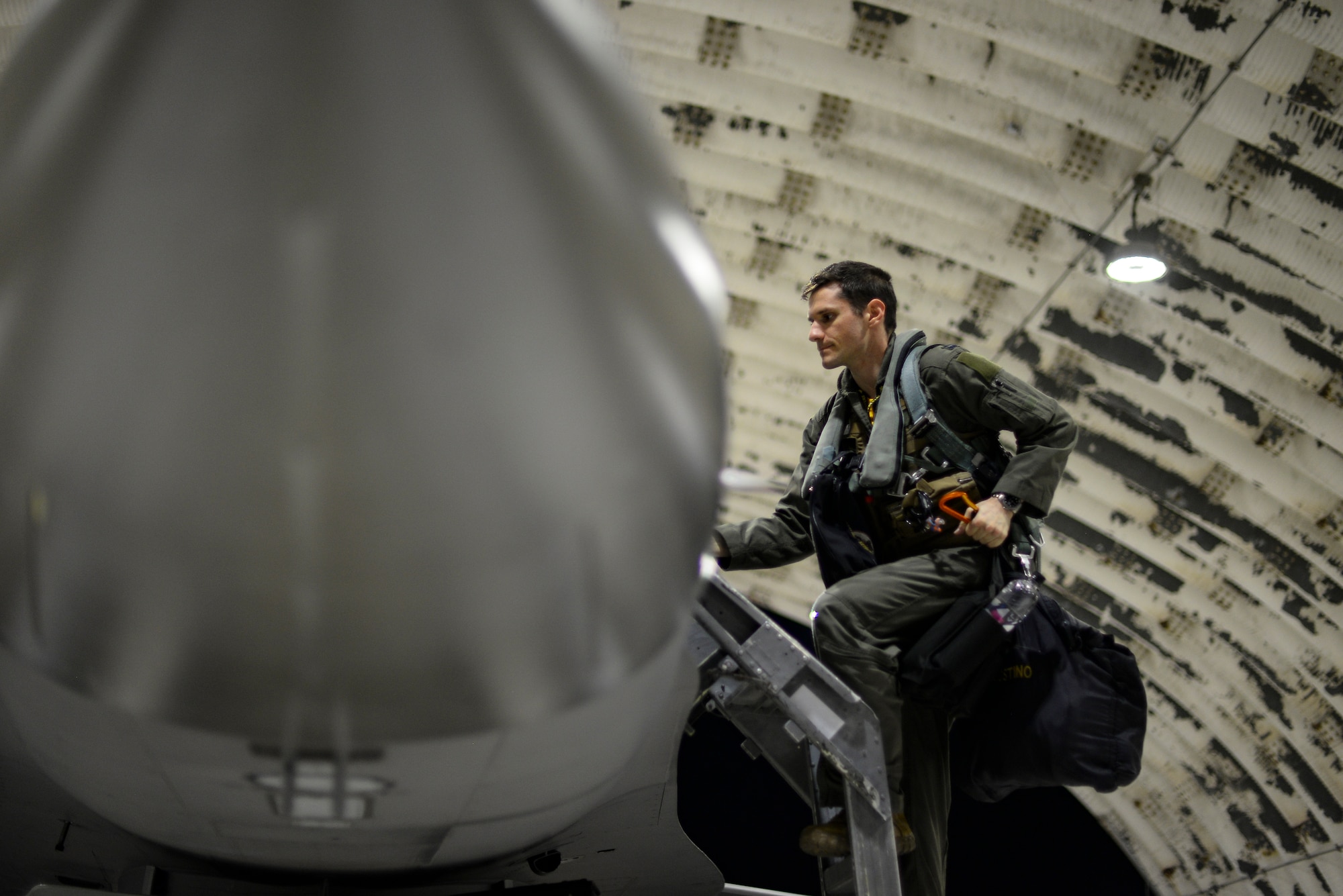 A pilot climbs into a jet.