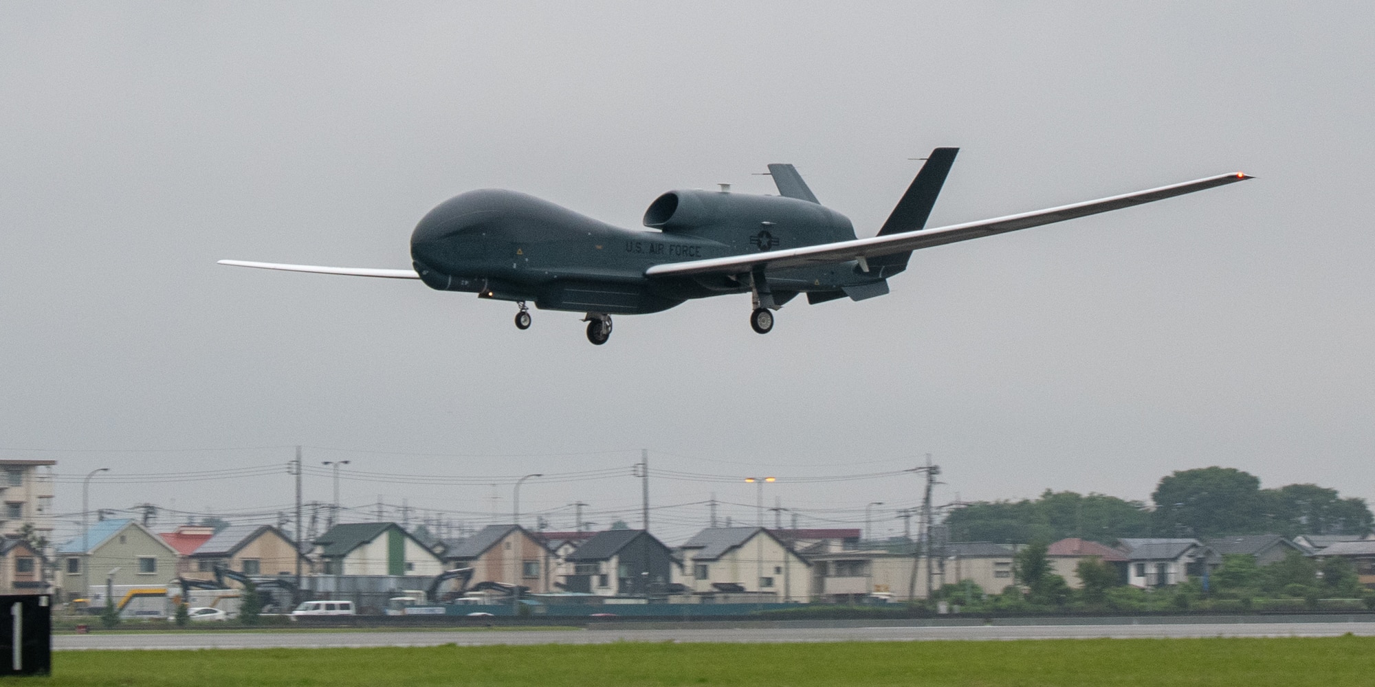 An RQ-4 Global Hawk, assigned to the 4th Reconnaissance Squadron, 319th Operation Group, Andersen Air Force Base, Guam, lands at Yokota Air Base, Japan, May, 22, 2021, for a rotational deployment. The movement maintains operations for Global Hawks during months of inclement weather on Guam. (U.S. Air Force photo by Yasuo Osakabe)