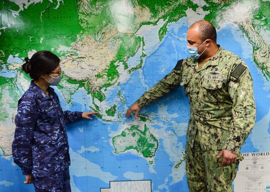 SINGAPORE (May 5, 2021) – Japan Maritime Self-Defense Force (JMSDF) Lt. Cmdr. Yoko Ukegawa, JMSDF liaison officer at Commander, Logistics Group Western Pacific (COMLOG WESTPAC), and U.S. Navy Lt. William Anthony, assistant replenishment officer with COMLOG WESTPAC, discuss potential replenishment-at-sea locations in the COMLOG WESTPAC conference room. (U.S. Navy photo by Mass Communication Specialist 1st Class Greg Johnson)