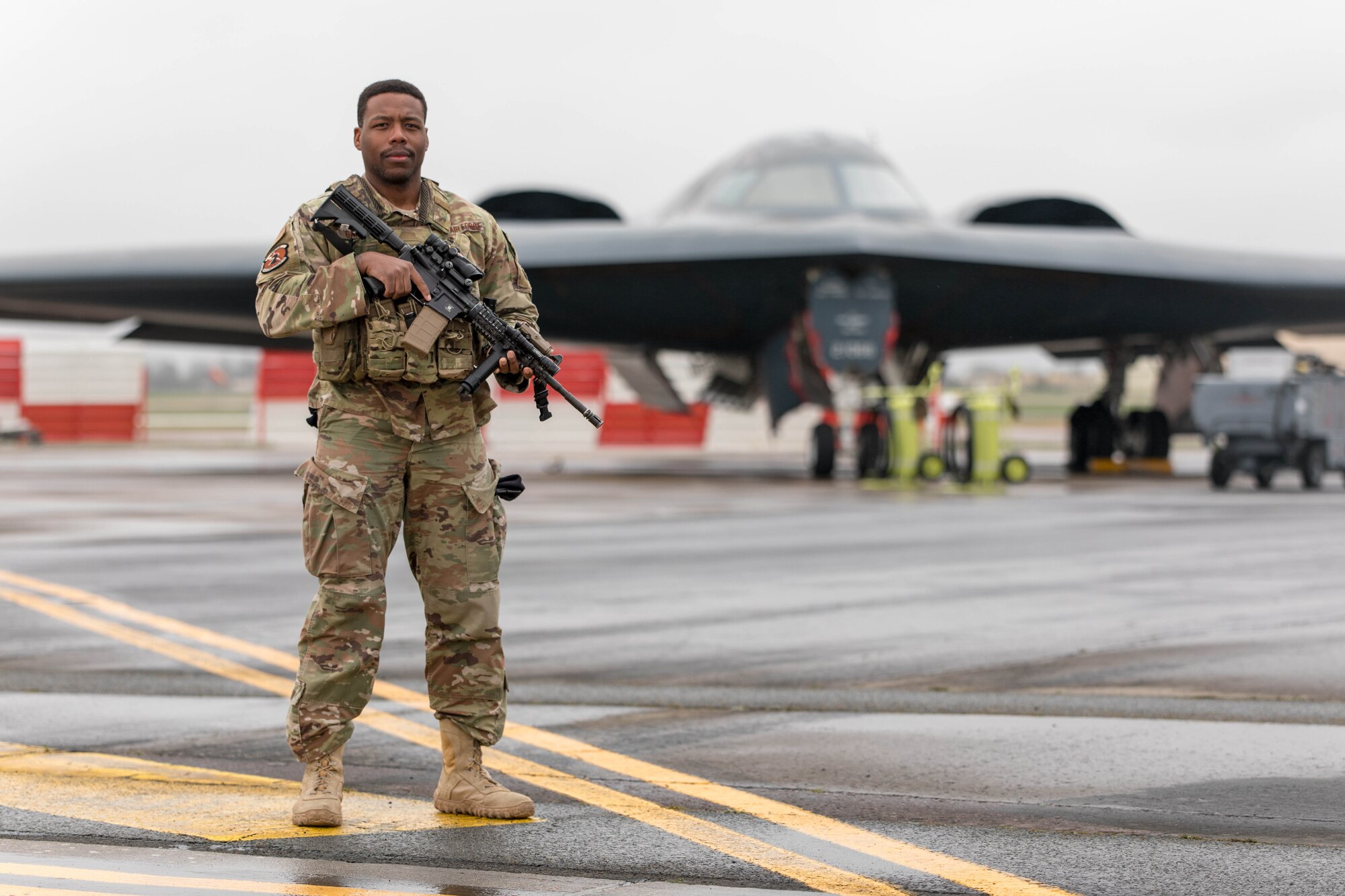 U.S. Air Force Senior Airman Trevon Gardner, assigned to the 5th Security Forces Squadron at Minot Air Base, North Dakota, poses for a portrait in front of a B-2 Spirit on March 19, 2020, at RAF Fairford, United Kingdom. Gardner deployed to RAF Fairford in support of Bomber Task Force Europe operations, which tests the readiness of the Airmen and equipment that support it, as well as their collective ability to operate at forward locations. (U.S. Air National Guard photo by Tech. Sgt. Colton Elliott)