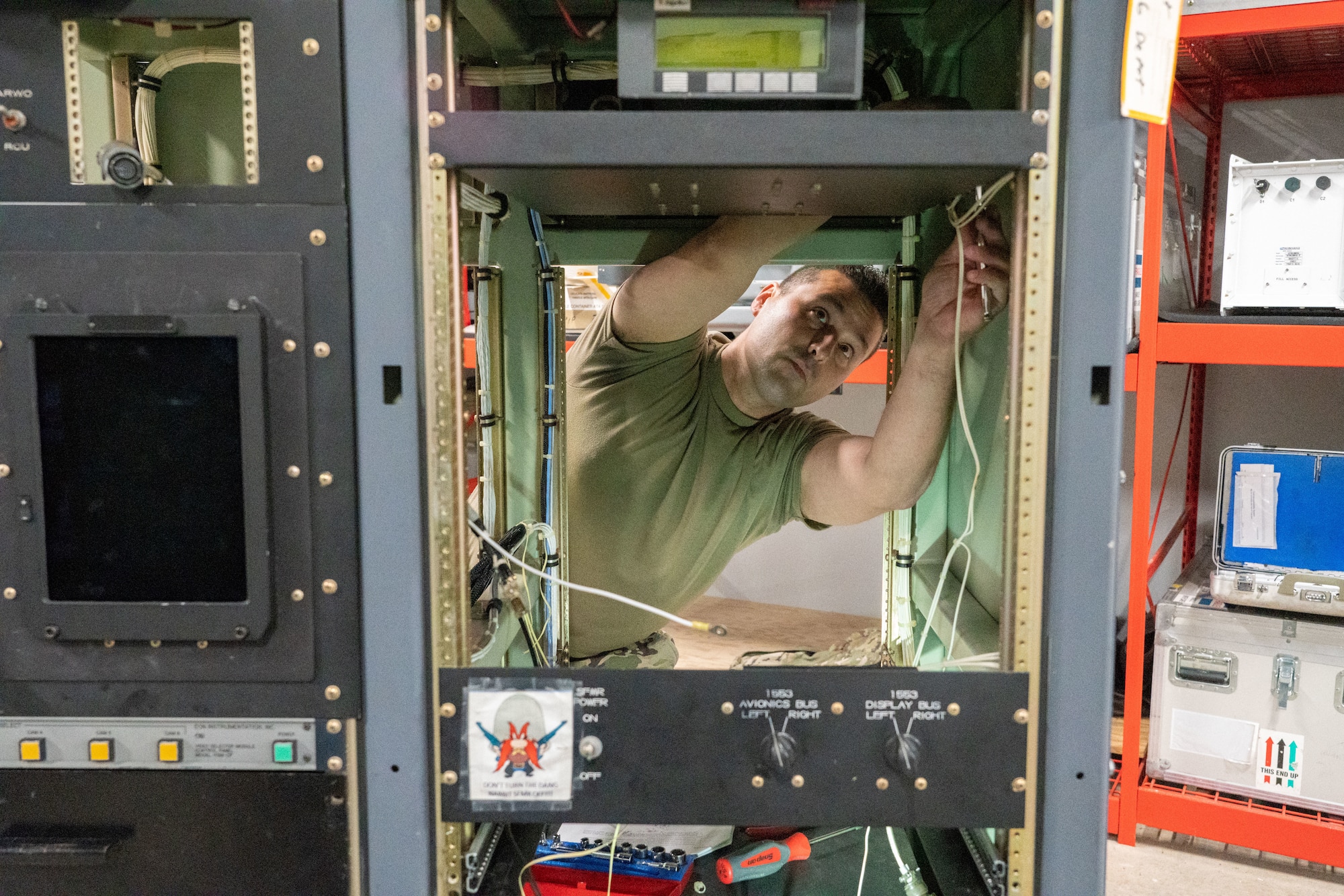 Senior Airman Warren Reynier, 403rd Maintenance Squadron meteorology technician, works on the internal wiring of the aerial reconnaissance weather officer station at Keesler Air Force Base, Miss., May 12, 2021. The 53rd Weather Reconnaissance Squadron “Hurricane Hunters’” ARWO and loadmaster/dropsonde operator stations are being upgraded with hardware and software to increase their weather collecting capabilities. (U.S. Air Force photo by 2nd Lt. Christopher Carranza)