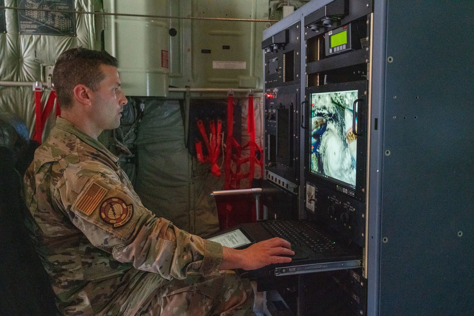 Senior Airman Warren Reynier, 403rd Maintenance Squadron meteorology technician, runs an operations check on the upgraded monitor of the aerial reconnaissance weather officer station at Keesler Air Force Base, Miss., May 13, 2021. The 53rd Weather Reconnaissance Squadron “Hurricane Hunters’” ARWO and loadmaster/dropsonde operator stations are being upgraded with hardware and software to increase their weather collecting capabilities. (U.S. Air Force photo by 2nd Lt. Christopher Carranza)