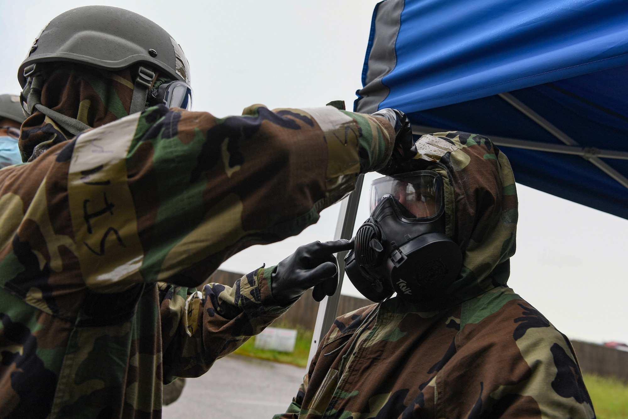 U.S. Air Force Senior Airman Patrick Kelly, 724th Air Mobility Squadron (AMS) aircraft services technician, left, buddy checks Airman Jaden Boswell, 724th AMS freight service technician during exercise Nodal Lightning, at Aviano Air Base, Italy, May 19, 2021. Nodal Lightning is an exercise conducted by the 521st Air Mobility Operations Wing, which tests readiness in air mobility units around U.S. Air Forces in Europe. (U.S. Air Force photo by Airman 1st Class Thomas S. Keisler IV)