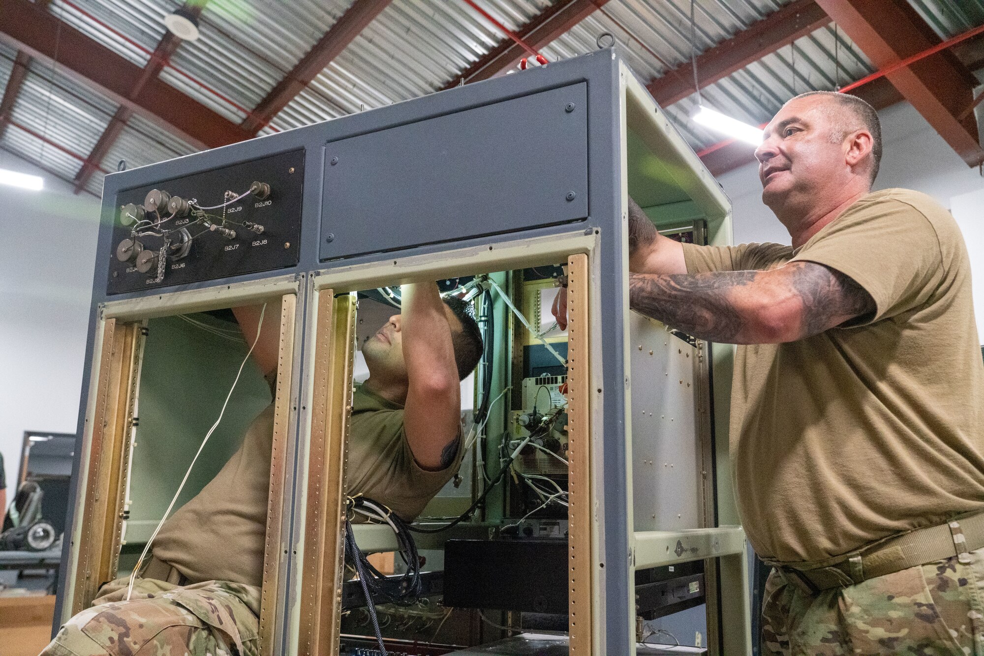 Senior Airman Warren Reynier and Master Sgt. Alexander Mitchell, 403rd Maintenance Squadron meteorology technicians, work on the internal wiring of the aerial reconnaissance weather officer station at Keesler Air Force Base, Miss., May 12, 2021. The 53rd Weather Reconnaissance Squadron “Hurricane Hunters’” ARWO and loadmaster/dropsonde operator stations are being upgraded with hardware and software to increase their weather collecting capabilities. (U.S. Air Force photo by 2nd Lt. Christopher Carranza)