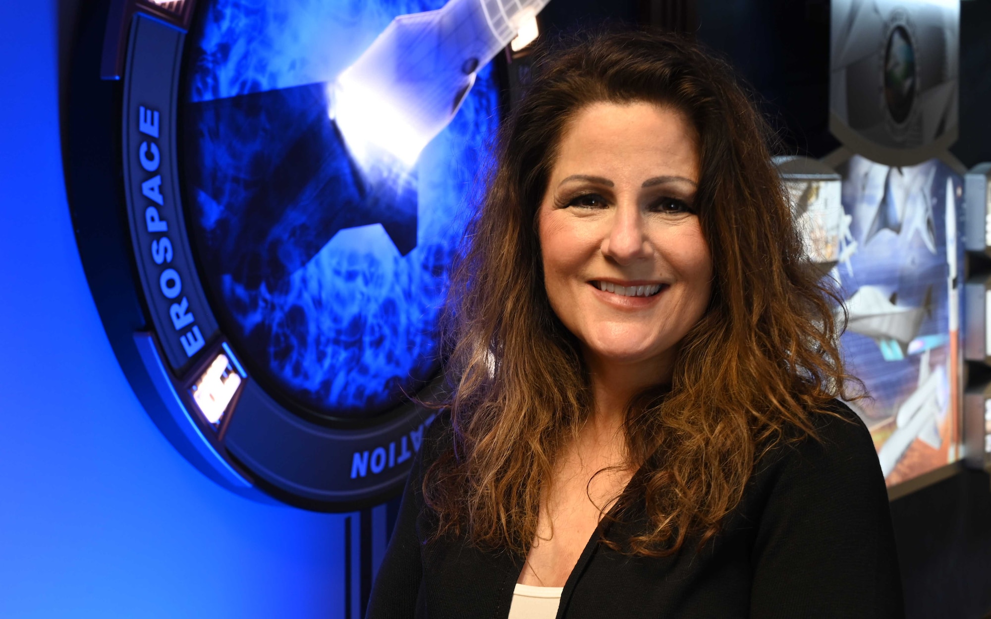 Lisa Fitzgerald, a senior technical advisor with the Aerospace Systems Directorate, smiles in her work environment, May 7, 2021. Fitzgerald's diverse career experiences inspired her daughter to attend the Air Force Academy and follow in her mother's footsteps by serving in the military. (U.S. Air Force photo/Rachel Simones)