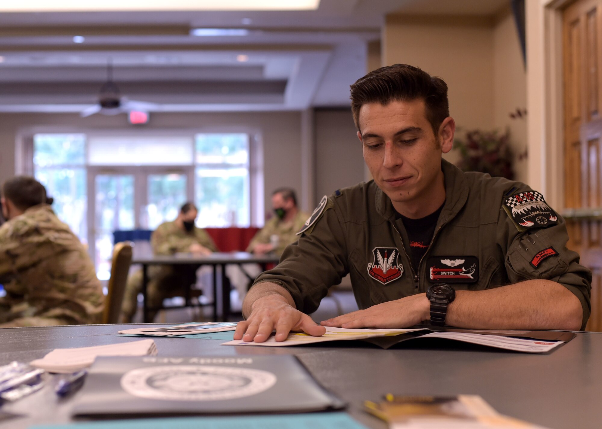 Airman sitting at table looking at reference material