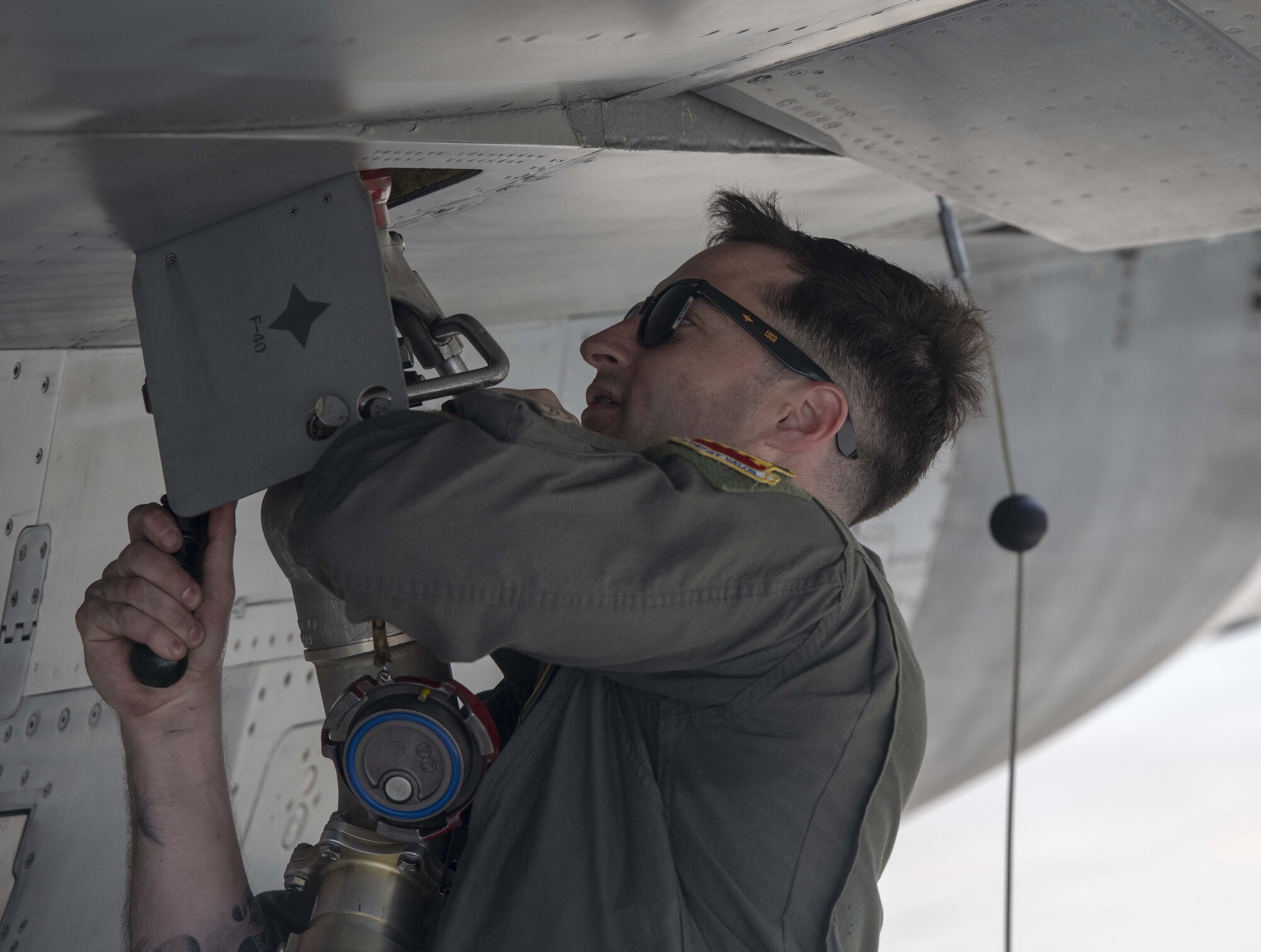 A F-16 pilot works on a jet.