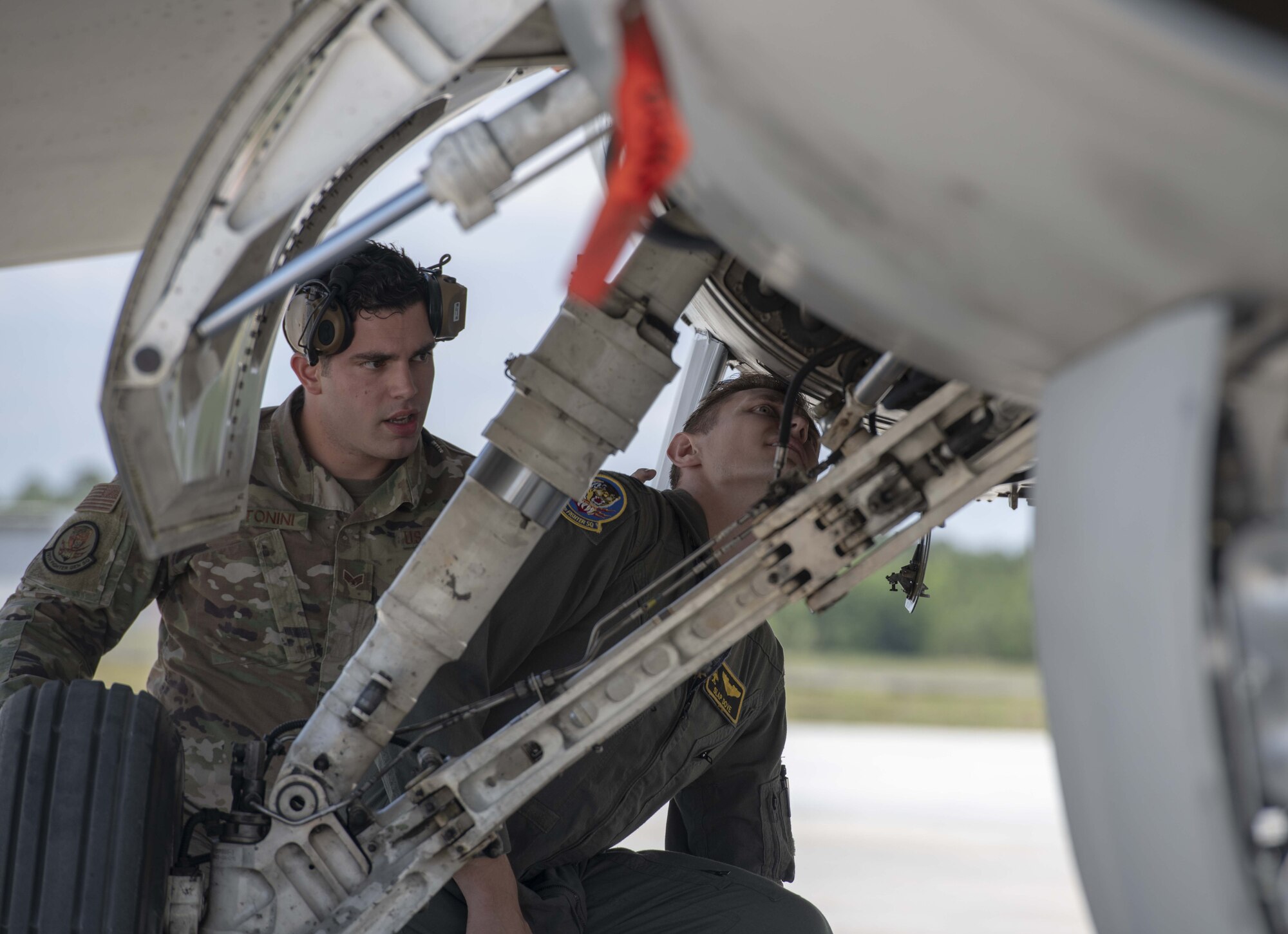 A photo of Airmen looking into a jet.