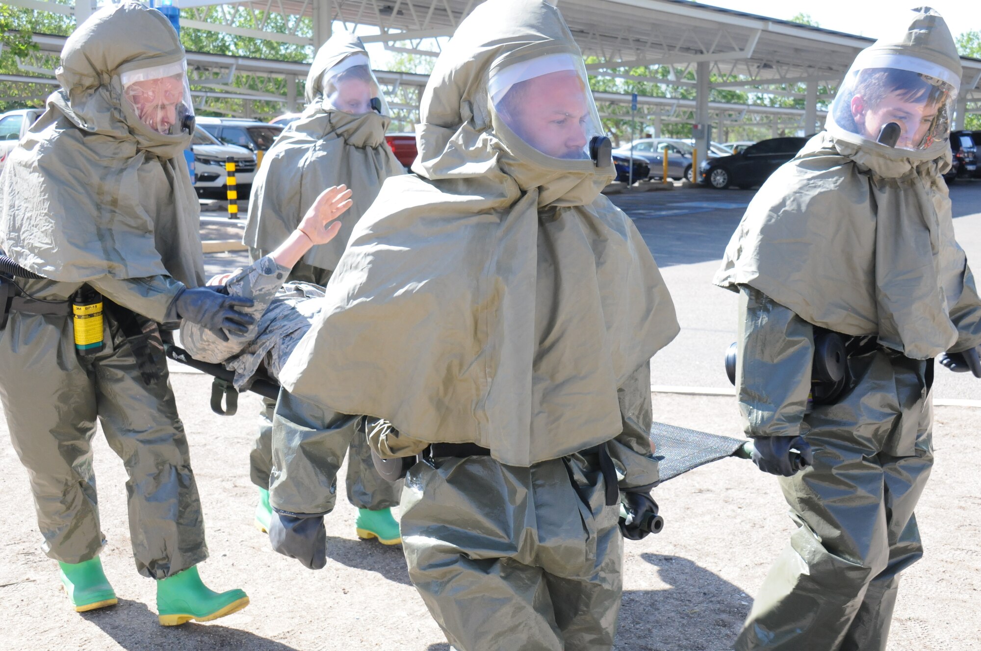 Military medics carry a simulated patient on a litter.
