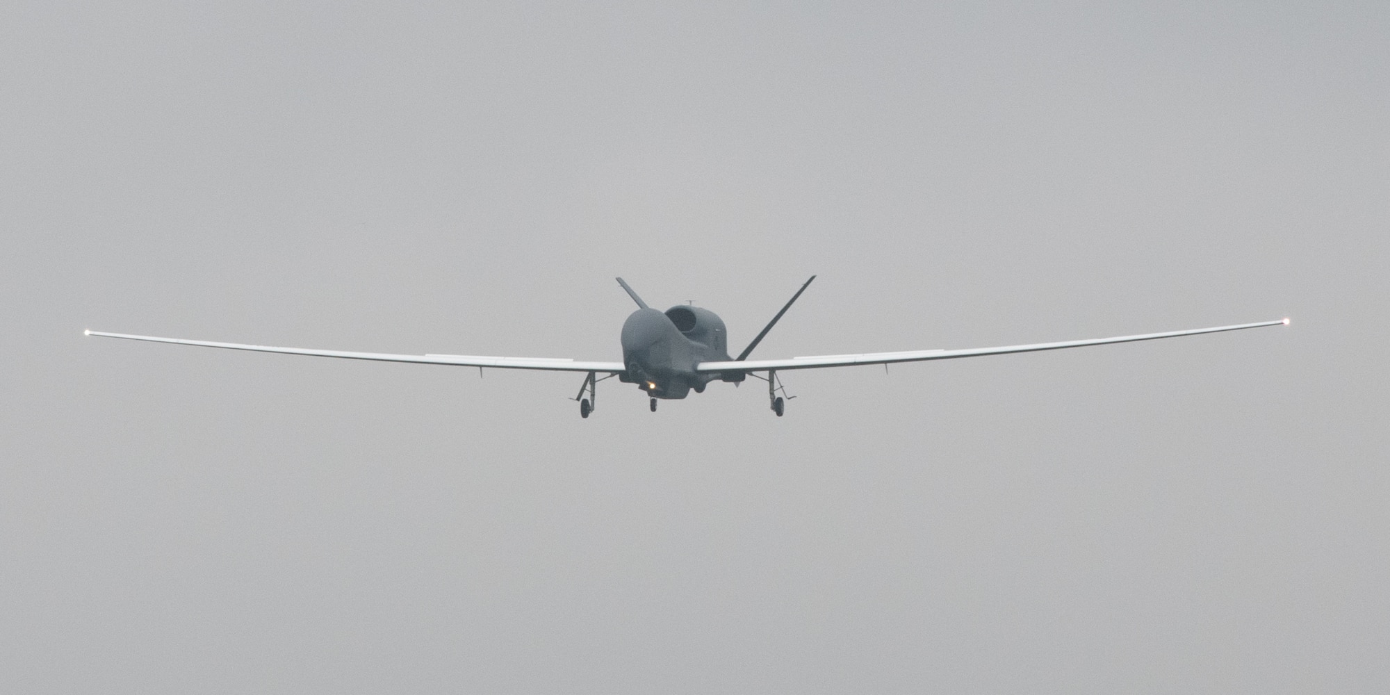 An RQ-4 Global Hawk, assigned to the 4th Reconnaissance Squadron, 319th Operation Group, Andersen Air Force Base, Guam, approaches at Yokota Air Base, Japan, May, 22, 2021, for a rotational deployment. The movement maintains operations for Global Hawks during months of inclement weather on Guam. (U.S. Air Force photo by Yasuo Osakabe)