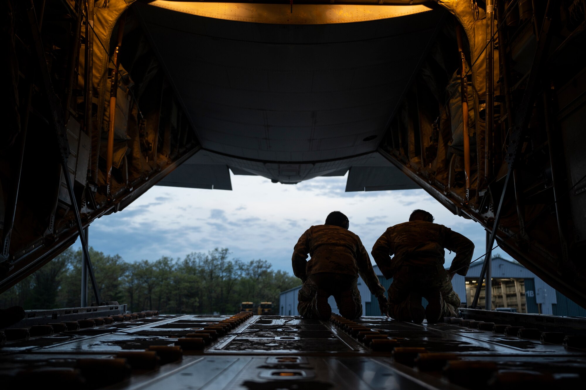 Airmen guide pilots operating a C-130J