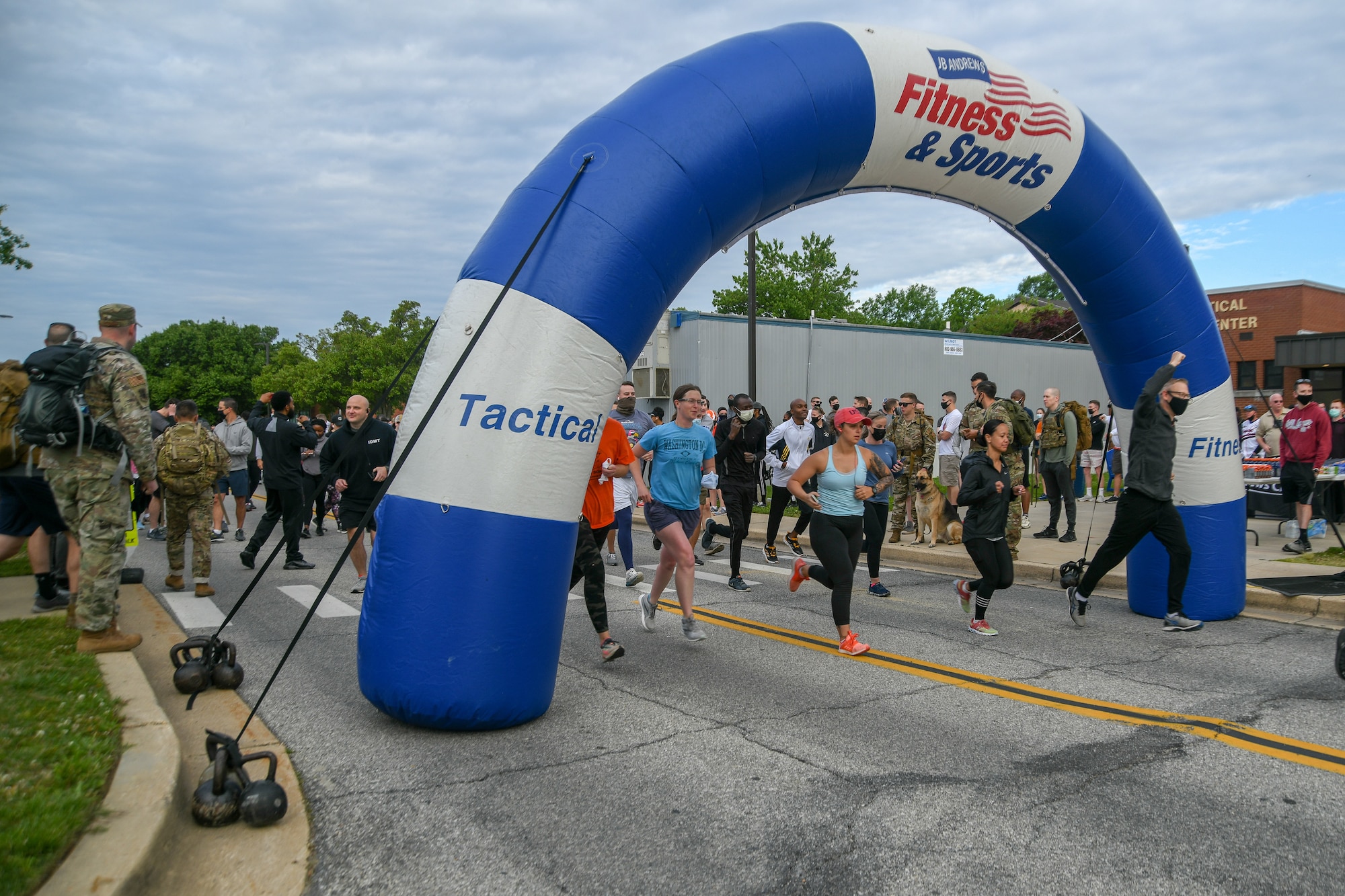 Service members cross the finish line of a 5-kilometer race during Wingman/Shipmate Day at Joint Base Andrews, Md., May 11, 2021. Wingman/Shipmate Day is a chance for service members to compete and strengthen the bonds between squadrons at JBA, with activities such as basketball, golf, tennis, music and other family events. (U.S. Air Force photo by Airman 1st Class Bridgitte Taylor)