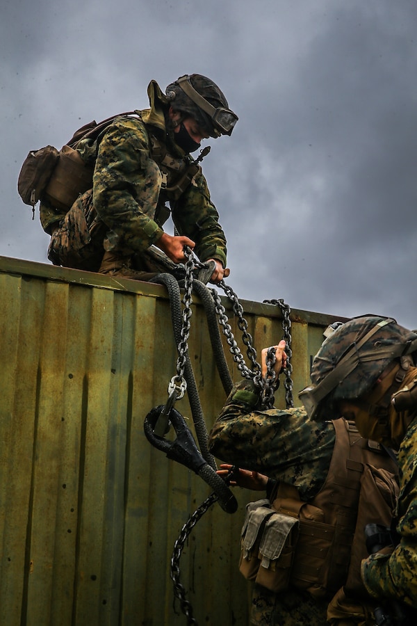 U.S. Marines with Landing Support Battalion, Combat Logistics Regiment 3, 3d Marine Logistics Group, prepare a quadcon to be attached to and transported by a CH-53 Super Stallion during exercise Pacific Pioneer at Torii Station, Okinawa, Japan, April 22, 2021. Pacific Pioneer serves as 9th Engineer Support Battalion's Marine Corps Combat Readiness Evaluation as well as an opportunity to demonstrate the ability to establish and sustain expeditionary advanced bases with survivable force protection, practice naval integration, and position long range precision fires and tactical logistics nodes across littoral regions in support of naval operations. 3d MLG, based out of Okinawa, Japan, is a forward deployed combat unit that serves as III MEF’s comprehensive logistics and combat service support backbone for operations throughout the Indo-Pacific area of responsibility. (U.S. Marine Corps photo by Sgt. Hailey D. Clay)