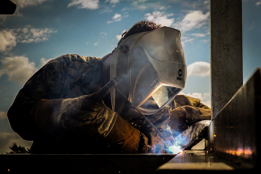 U.S. Marine Corps Lance Cpl. Htoo Htoo Baw, metal worker with Engineer Support Company, 9th Engineer Support Battalion, 3d Marine Logistics Group, welds pieces of metal together in support of 9th ESB’s Explosive Ordnance Disposal Marines on Kin Blue training area, Okinawa, Japan, April 20, 2021. Pacific Pioneer serves as 9th ESB's Marine Corps Combat Readiness Evaluation as well as an opportunity to demonstrate the ability to establish and sustain expeditionary advanced bases with survivable force protection, practice naval integration, and position long range precision fires and tactical logistics nodes across littoral regions in support of naval operations. 3d MLG, based out of Okinawa, Japan, is a forward deployed combat unit that serves as III MEF’s comprehensive logistics and combat service support backbone for operations throughout the Indo-Pacific area of responsibility. Baw is a native of Smyrna, Tennessee. (U.S. Marine Corps photo by Sgt. Hailey D. Clay)