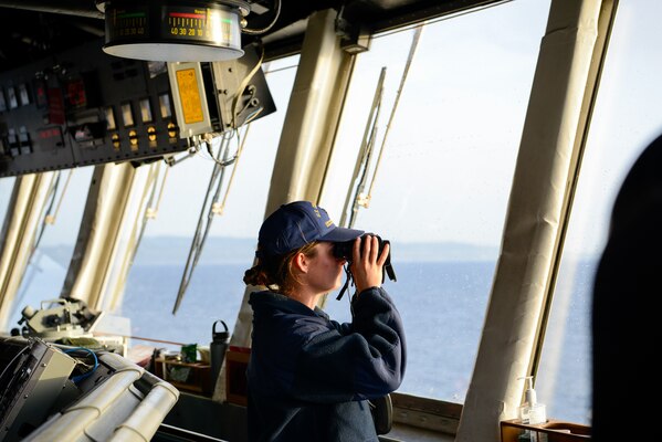 210522-G-ID129-4064 MEDITERRANEAN SEA (May 22, 2021) Seaman Cheyenne Solis Headlam looks out from the bridge as they transit out of the Mediterranean Sea, May 22, 2021. Hamilton is on a routine deployment in the U.S. Sixth Fleet area of operations in support of U.S. national interests and security in Europe and Africa. (U.S. Coast Guard photo by Petty Officer 3rd Class Sydney Phoenix)