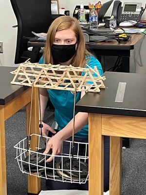 Transatlantic Middle East District Fire Protection Engineer assists with the weight bearing portion of the bridge build project at a recent STARBASE Academy Winchester presentation.