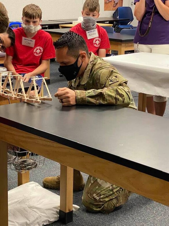 Transatlantic Middle East District Deputy Commander MAJ Eder Ramirez assists students with the weight bearing portion of the bridge build project at a recent STARBASE Academy Winchester presentation.