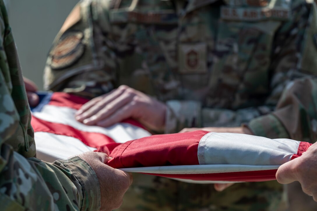 A flag is folded during a retreat ceremony held by the Team Dover Chief’s Group and First Sgt. Council at Dover Air Force Base, Delaware, May 20, 2021. Retreat is used to pay respects to the flag and signifies the end of the duty day. (U.S. Air Force photo by Airman 1st Class Cydney Lee)