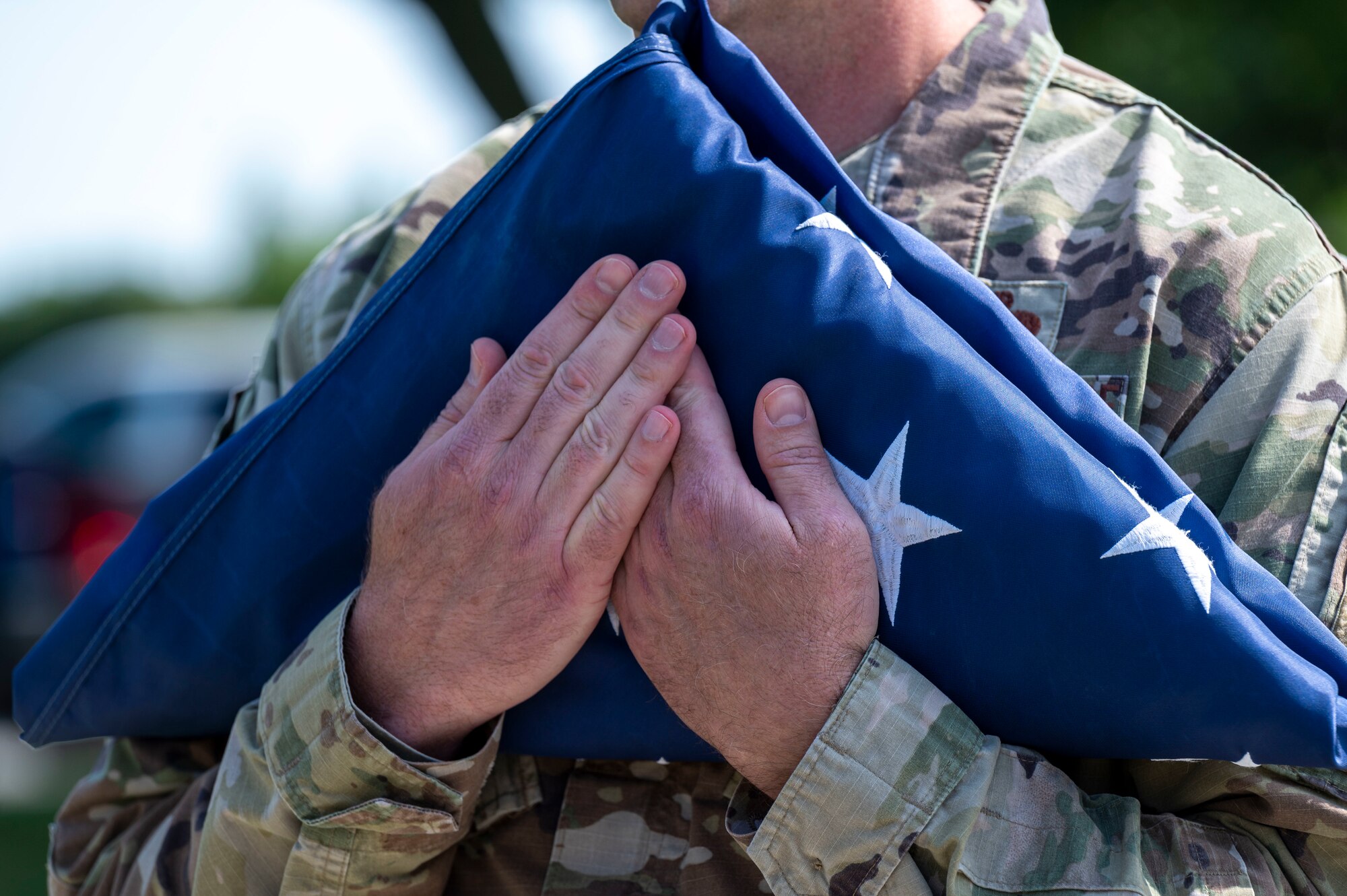 A member of Team Dover’s Chief’s Group holds a folded flag to his chest during a retreat ceremony at Dover Air Force Base, Delaware, May 20, 2021. Different units conduct the ceremony each week to instill pride, heritage and esprit de corps. (U.S. Air Force photo by Airman 1st Class Cydney Lee)