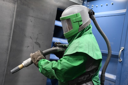 Martin Trzcinski, Code 970, Preservation Mechanic, outfitted in the required personal protective equipment (PPE) to operate the Critical Coat Blast Booth in Shop 71.