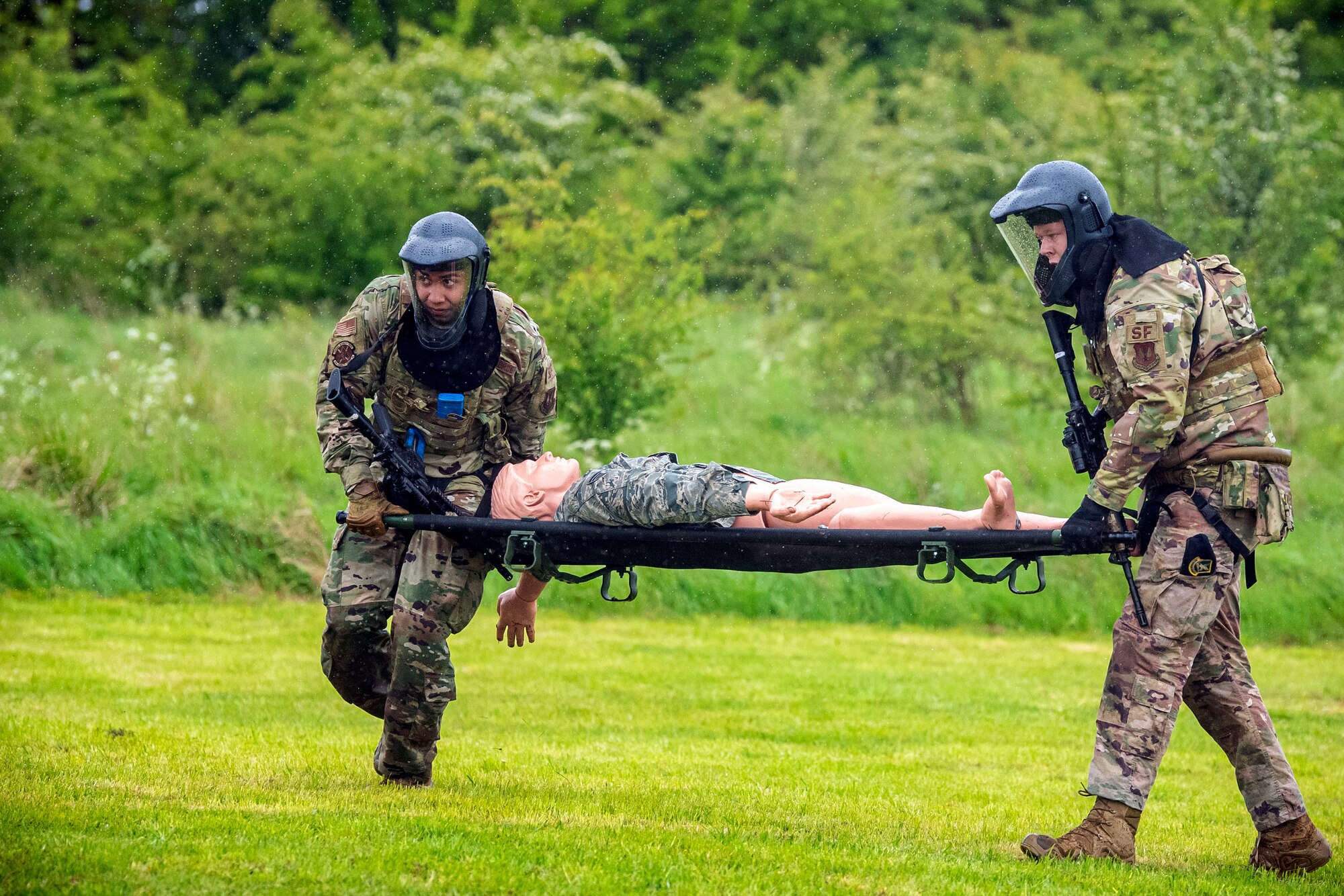 Airmen from the 423rd Security Forces Squadron carry a simulated victim on a stretcher during a Force-on-Force exercise at RAF Molesworth, England, May 21, 2021. Defenders from the 422d and 423rd SFS came together to sharpen their shoot, move, communicate tactics as they responded to multiple scenarios geared towards sharpening their skills in deadly force situations. (U.S. Air Force photo by Senior Airman Eugene Oliver)