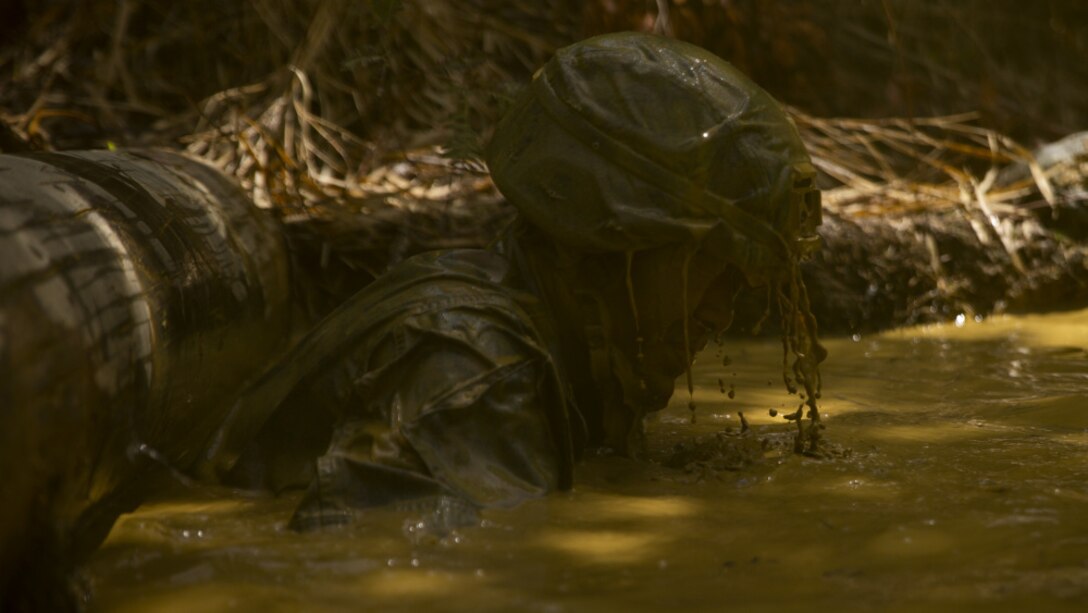 U.S. Marine Corps Lance Cpl. Kenneth Ofamin, a warehouse clerk with 3rd Reconnaissance Battalion, 3rd Marine Division, swims under an obstacle during the endurance course at the Basic Jungle Survival Course on Camp Gonsalves, Okinawa, Japan, April 29, 2021. BJSC prepares Marines and joint partners to fight in jungle environments.