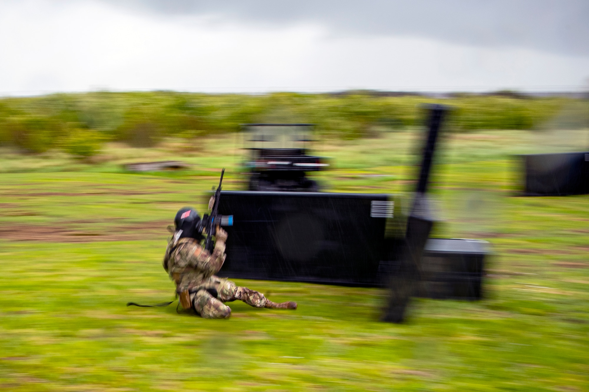 An Airman from the 422d Security Forces Squadron slides to cover during a Force-on-Force exercise at RAF Molesworth, England, May 21, 2021. Defenders from the 422d and 423rd SFS came together to sharpen their shoot, move, communicate tactics as they responded to multiple scenarios geared towards sharpening their skills in deadly force situations. (U.S. Air Force photo by Senior Airman Eugene Oliver)
