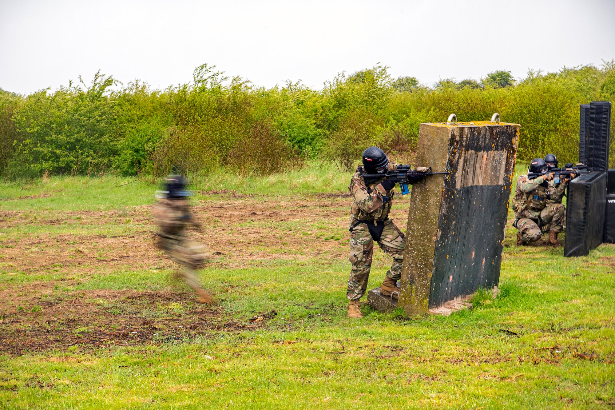 An Airman from the 423rd Security Forces Squadron, left, advances his position during a Force-on-Force exercise at RAF Molesworth, England, May 21, 2021.  Defenders from the 422d and 423rd SFS came together to sharpen their shoot, move, communicate tactics as they responded to multiple scenarios geared towards sharpening their skills in deadly force situations. (U.S. Air Force photo by Senior Airman Eugene Oliver)