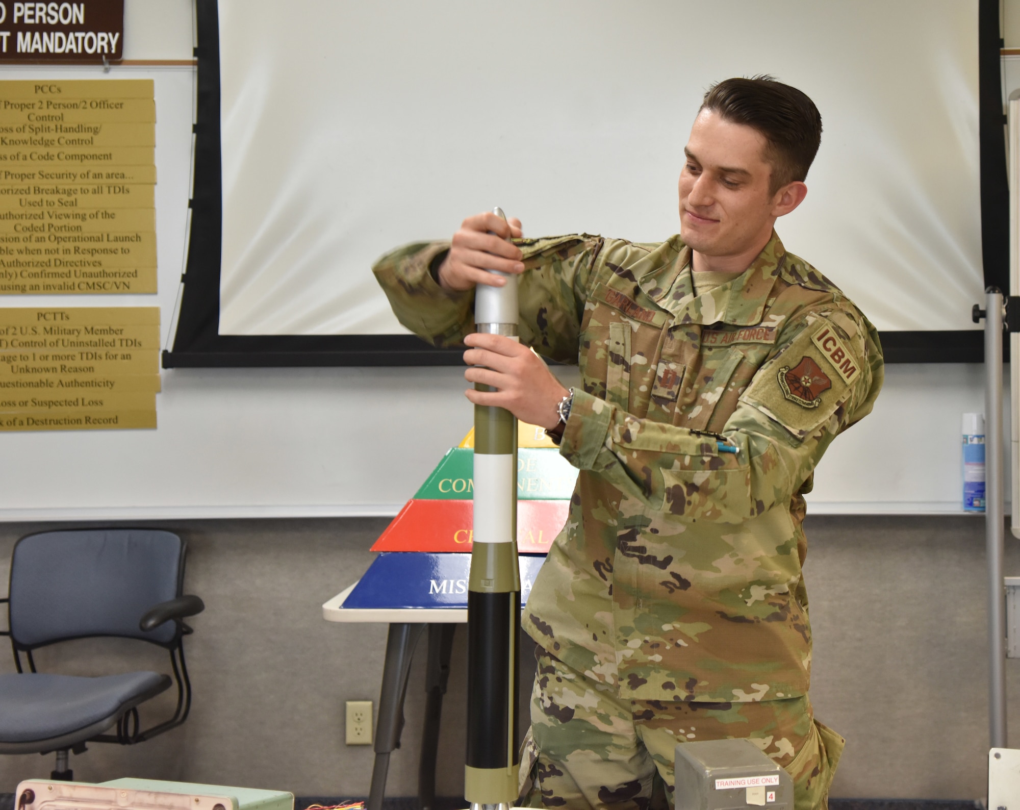 Capt. Alexander Garland, 341st Operations Support Squadron nuclear cryptographic operator, adjusts the top of a model intercontinental ballistic missile while demonstrating processes of a mock launch May 19, 2021, on Malmstrom Air Force Base, Mont. ICBM’s have been the bedrock of military global stability and remain safe, secure, reliable and effective through the use of the coding process. (U.S. Air Force photo by Tech. Sgt. Joseph Park)