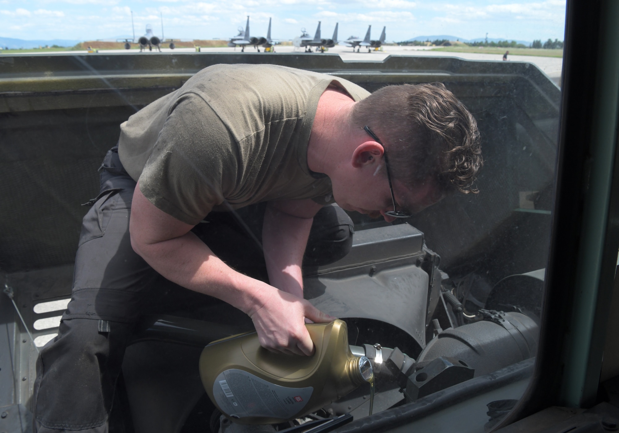 U.S. Air Force Staff Sgt. Kevin Grimm, 48th Logistics Readiness Squadron vehicle maintenance craftsman, tops off the oil on a refueling truck during exercise Astral Knight 21 at Larissa Air Base, Greece, May 20, 2021. During Astral Knight 21, the Liberty Wing sharpened its ability to deploy capable, credible forces to operate from strategic locations, which is enabled by strong regional partnerships critical for a rapid united response to adversaries around the world. (U.S. Air Force photo by Tech. Sgt. Alex Fox Echols III)