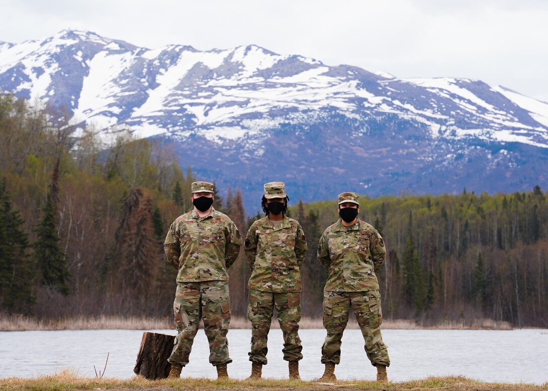From left to right: Tech. Sgt. Johnathan Thompson, Senior Airman Deniea Turner, and Staff Sgt. Michelle Aguilar-Villafuerte, all members of the 247th Intelligence Squadron, Tennessee Air National Guard, pose with the Chugach Mountains in the background May 12, 2021 at Joint Base Elmendorf-Richardson, Alaska. All three Airmen were in Alaska to support active-duty operations, and to learn new skillsets to bring back to their home unit. (U.S. Air Force photo by Senior Airman Justin Wynn)